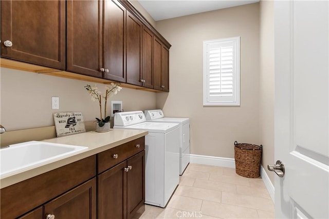 washroom featuring light tile patterned floors, sink, independent washer and dryer, and cabinets