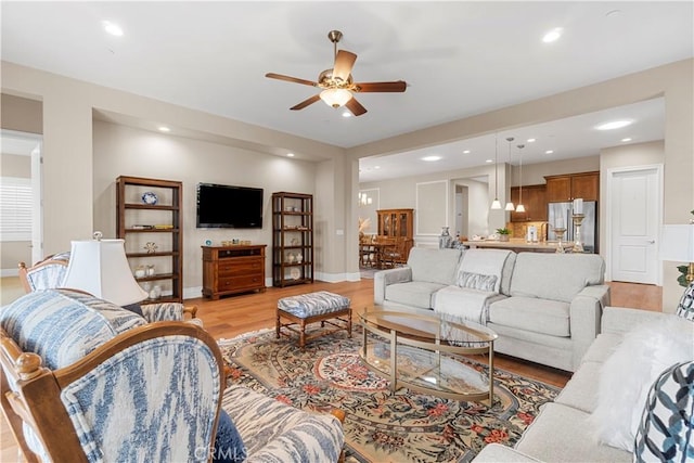 living room with ceiling fan and light hardwood / wood-style floors