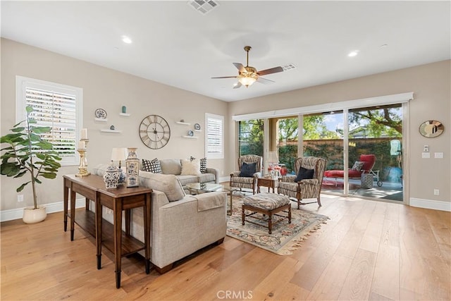 living room featuring ceiling fan, a healthy amount of sunlight, and light wood-type flooring