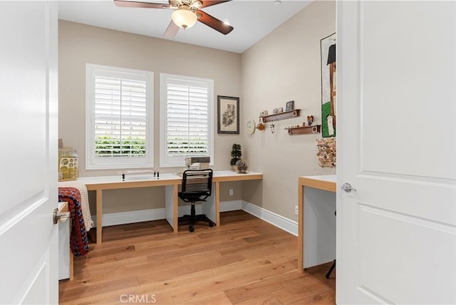 office area with built in desk, ceiling fan, and light hardwood / wood-style flooring