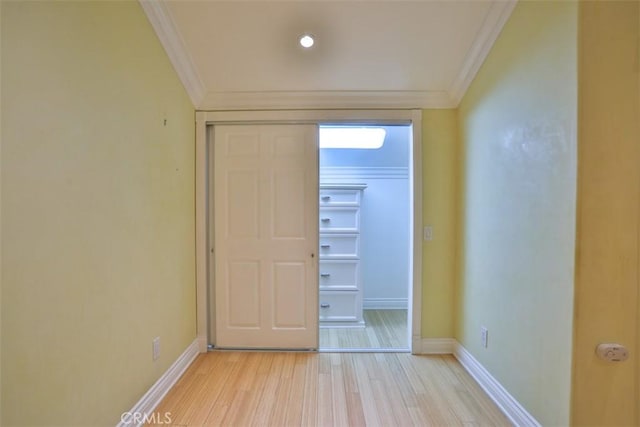 interior space with light wood-type flooring, a closet, and ornamental molding