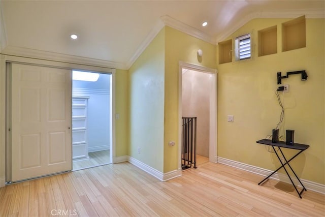 interior space featuring ornamental molding, lofted ceiling, and light hardwood / wood-style floors