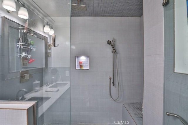 bathroom with sink, walk in shower, and ornamental molding