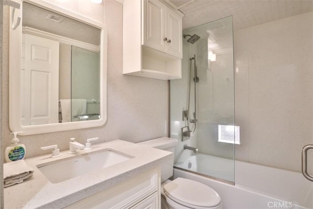 full bathroom featuring toilet, vanity, and shower / bath combination with glass door