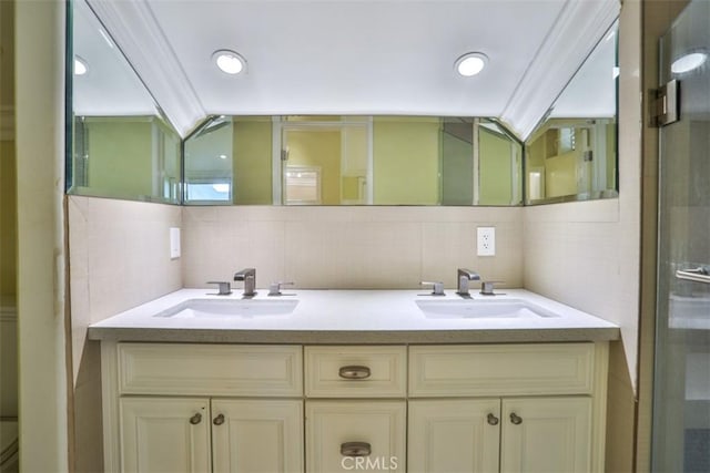 bathroom with vanity, backsplash, a shower with door, and crown molding