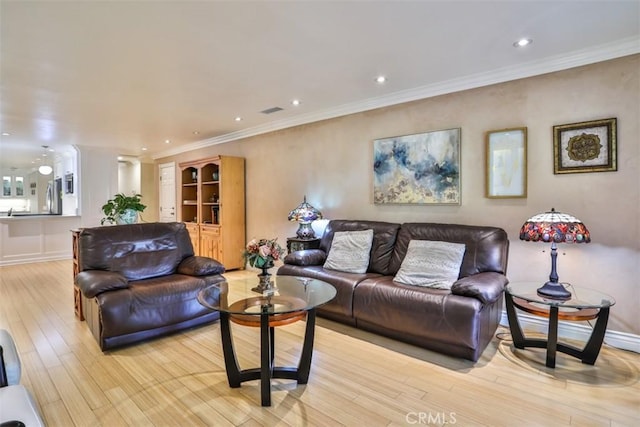 living room with crown molding and light hardwood / wood-style floors