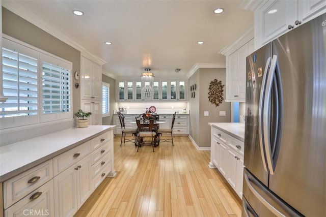 kitchen with light hardwood / wood-style floors, white cabinetry, stainless steel fridge, and a healthy amount of sunlight