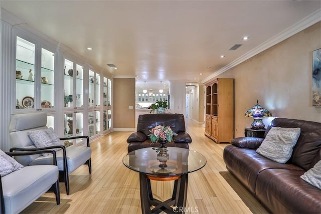 living room with ornamental molding and light hardwood / wood-style floors