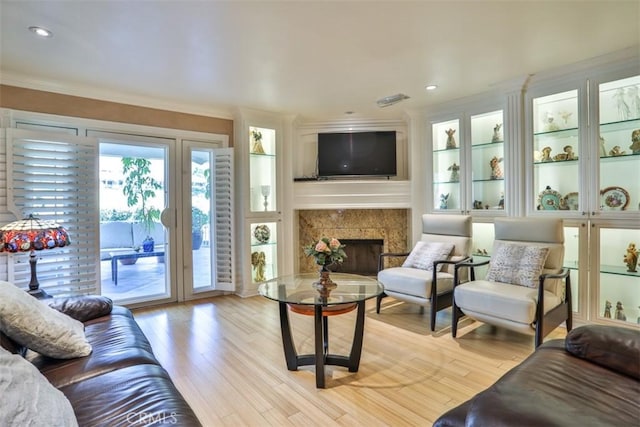 living room with crown molding and light hardwood / wood-style floors