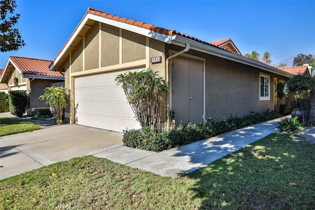 view of home's exterior with a garage and a lawn