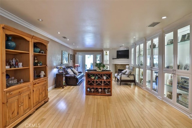 living room with ornamental molding and light wood-type flooring