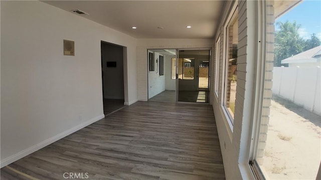 hallway featuring dark wood-type flooring and plenty of natural light