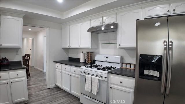 kitchen with white cabinets, gas range gas stove, and stainless steel fridge