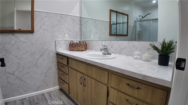 bathroom with an enclosed shower, vanity, and hardwood / wood-style floors