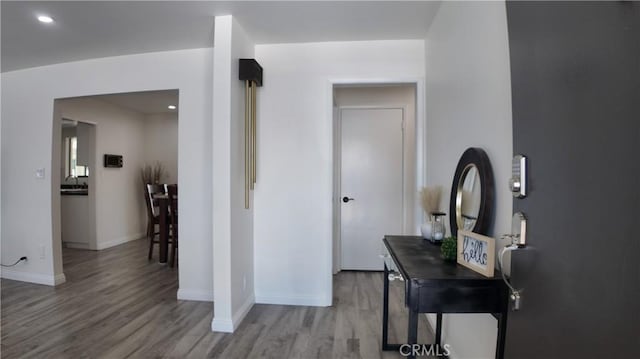 corridor with wood-type flooring and sink