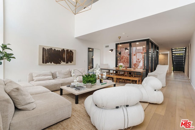 living room featuring a wall of windows, a chandelier, and light hardwood / wood-style flooring