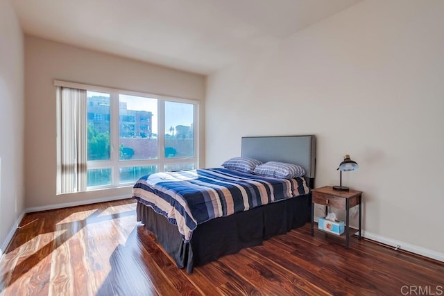 bedroom featuring dark wood-type flooring and multiple windows