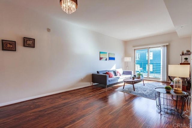 living room with dark hardwood / wood-style flooring and a chandelier