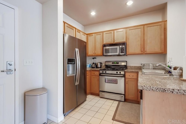 kitchen featuring light tile patterned floors, sink, light brown cabinetry, and appliances with stainless steel finishes