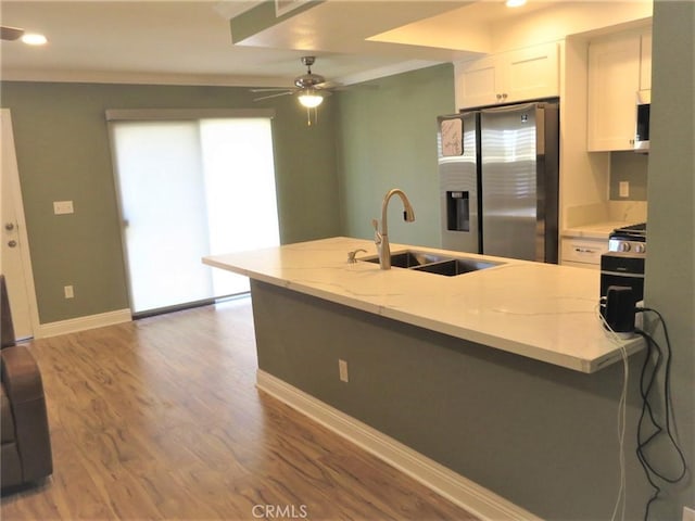 kitchen featuring light stone countertops, white cabinets, stainless steel refrigerator with ice dispenser, wood-type flooring, and sink