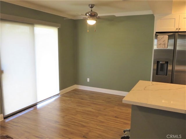 kitchen with ceiling fan, hardwood / wood-style floors, white cabinets, and ornamental molding