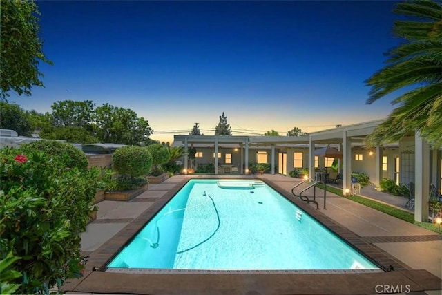 pool at dusk featuring a patio area