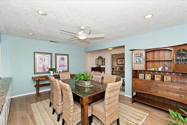 dining area featuring a textured ceiling, ceiling fan, and light hardwood / wood-style flooring