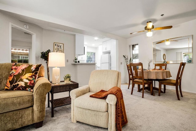 carpeted living room featuring ceiling fan and a wealth of natural light