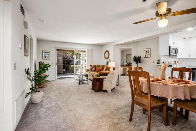 dining area with light carpet and ceiling fan