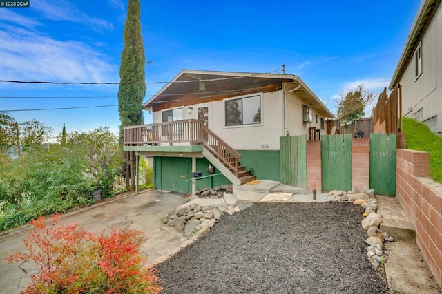 back of property featuring a wooden deck and a garage