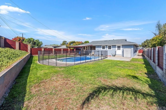 rear view of house featuring a lawn, a patio, and a fenced in pool