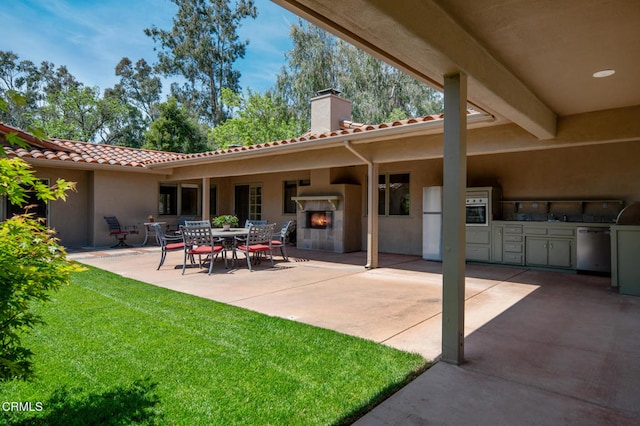 view of patio / terrace featuring an outdoor fireplace and an outdoor kitchen