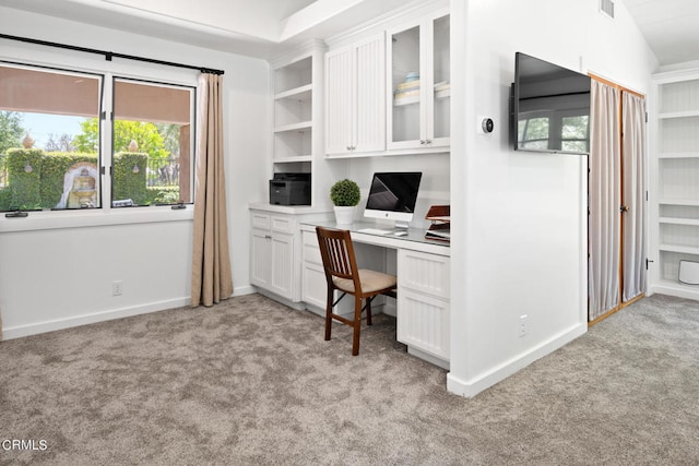 office space featuring built in desk, light colored carpet, and lofted ceiling