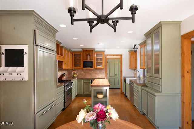 kitchen with high end stainless steel range, dark hardwood / wood-style flooring, backsplash, green cabinetry, and butcher block countertops