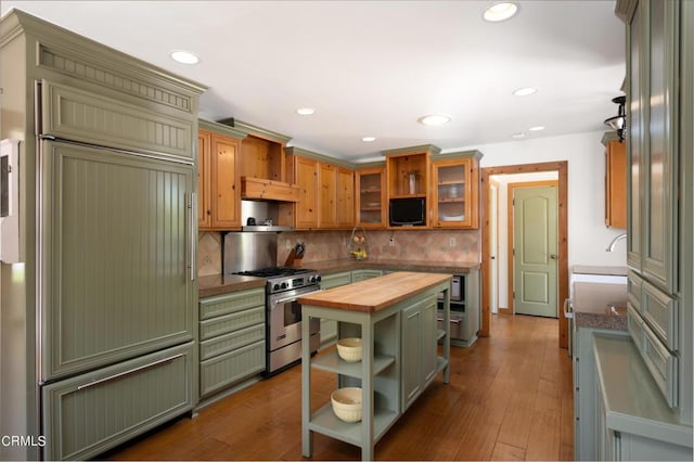 kitchen featuring wood counters, backsplash, dark wood-type flooring, stainless steel stove, and sink