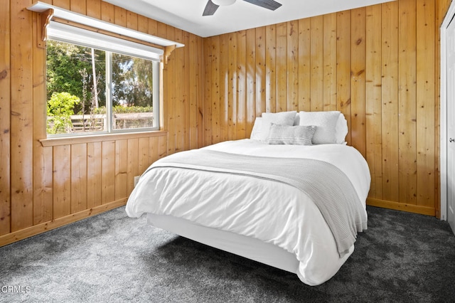 carpeted bedroom with ceiling fan and wooden walls