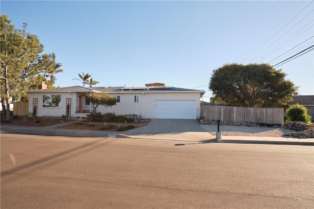 view of front of property with a garage and solar panels