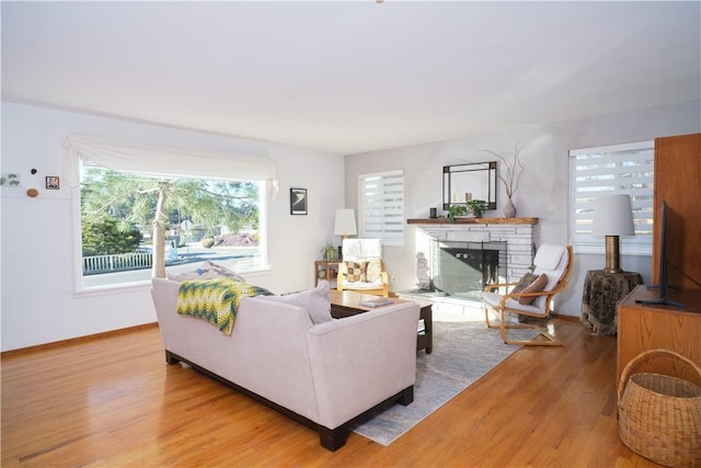 living room featuring light hardwood / wood-style flooring and a stone fireplace