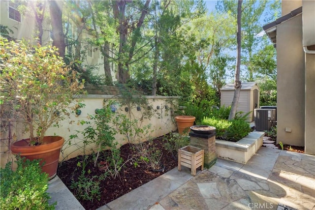 view of patio / terrace with central AC unit and a storage unit