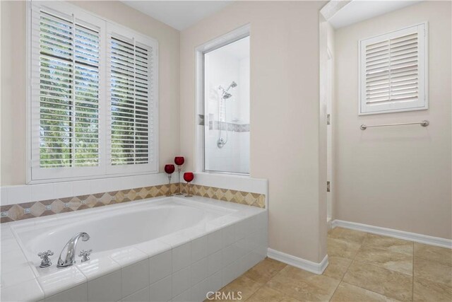 bathroom featuring tiled bath and tile patterned floors