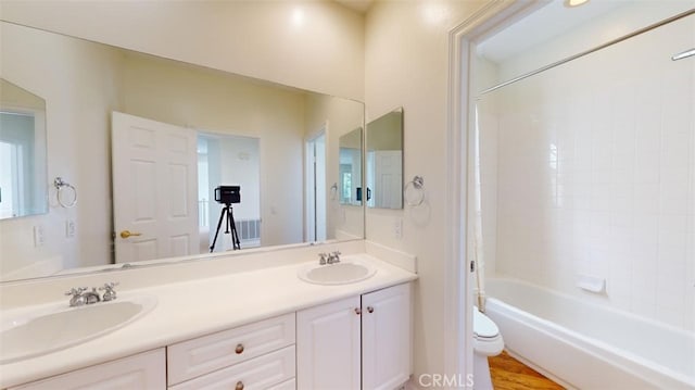 full bathroom with tiled shower / bath combo, vanity, and toilet