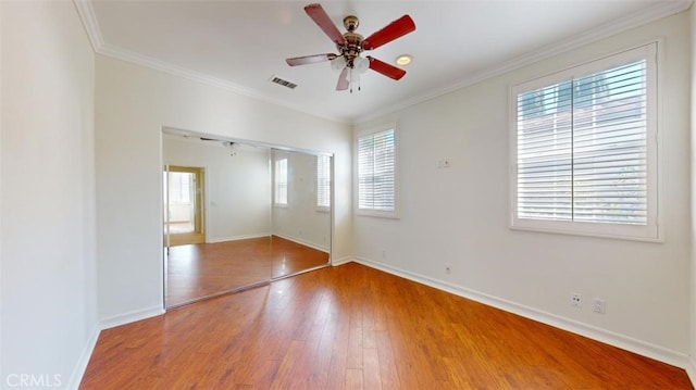 unfurnished bedroom with hardwood / wood-style flooring, ceiling fan, ornamental molding, and a closet