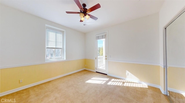 spare room with ceiling fan and light colored carpet