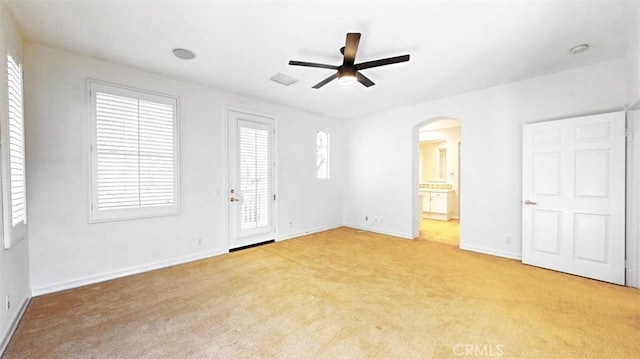 interior space featuring ceiling fan, light colored carpet, connected bathroom, and access to outside