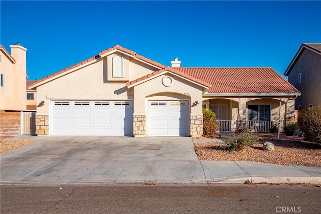 mediterranean / spanish-style home with covered porch and a garage