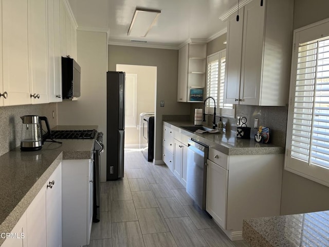 kitchen with sink, white cabinets, black appliances, and crown molding