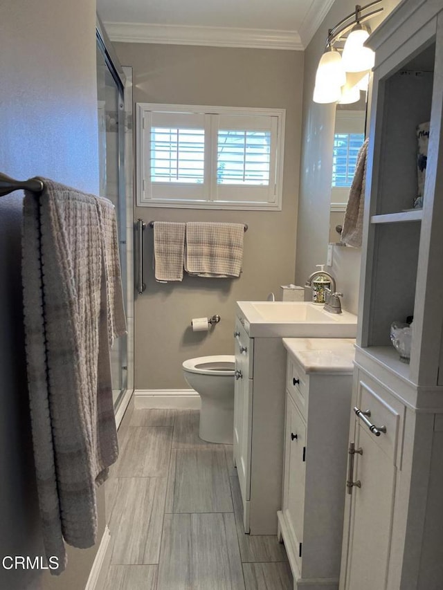 bathroom featuring walk in shower, vanity, crown molding, and toilet