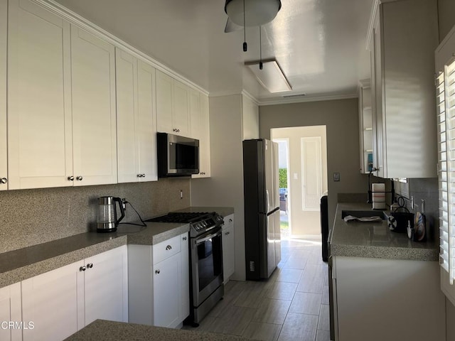 kitchen with plenty of natural light, appliances with stainless steel finishes, backsplash, and white cabinets