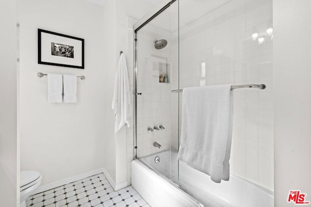 bathroom featuring enclosed tub / shower combo and toilet