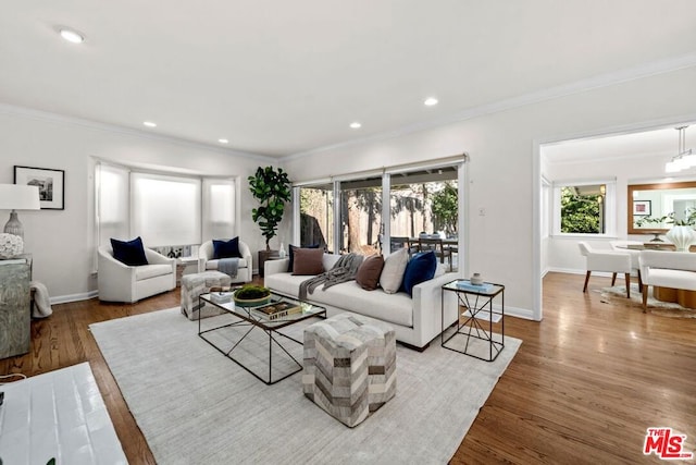 living room featuring hardwood / wood-style flooring, crown molding, and a chandelier